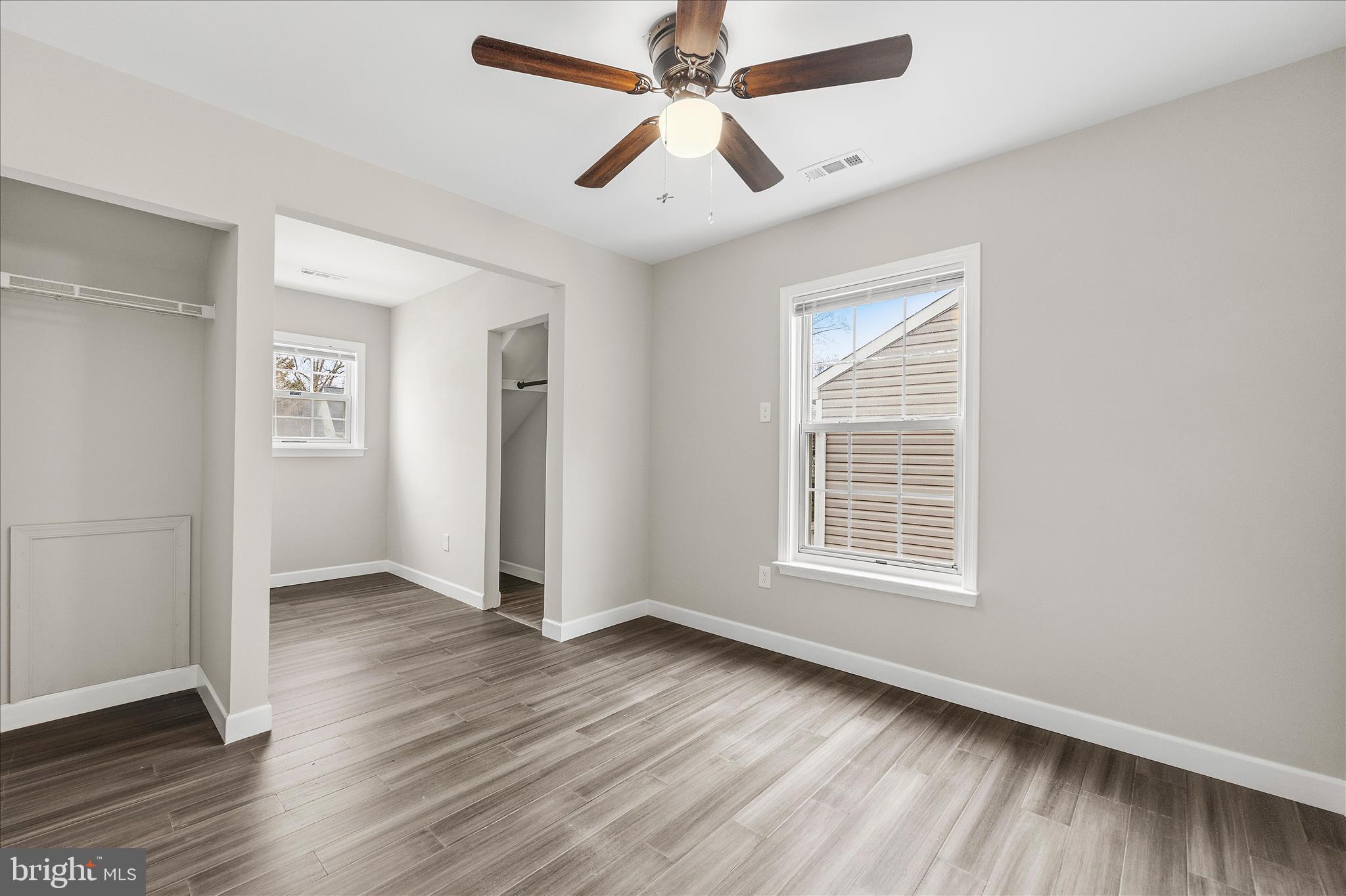 2209 227th Street Pasadena, MD 21122 - Photo 17 of 42 an empty room with wooden floor chandelier fan and windows
