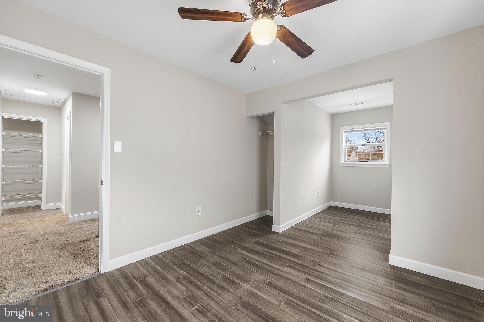 2209 227th Street Pasadena, MD 21122 - Photo 18 of 42 an empty room with wooden floor chandelier fan and windows