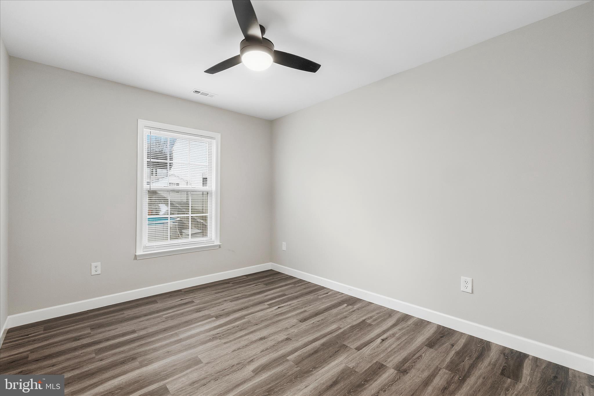 2209 227th Street Pasadena, MD 21122 - Photo 20 of 42 an empty room with wooden floor and windows