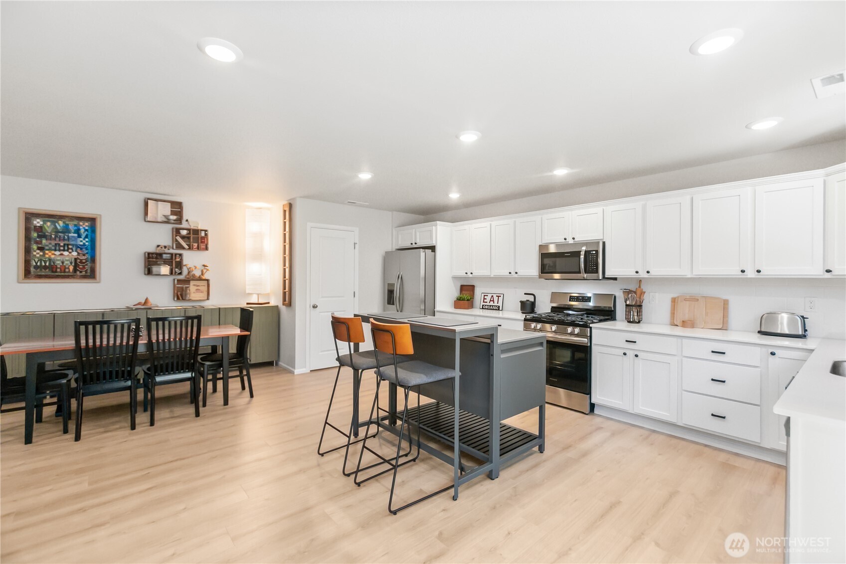 111 Northeast Ridgetop Crossing Belfair, WA 98528 - Photo 15 of 40 a kitchen with white cabinets and chairs