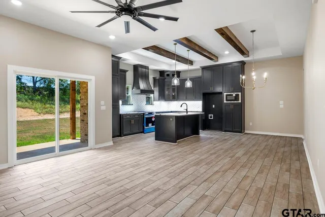 a view of kitchen with stainless steel appliances granite countertop cabinets and wooden floor