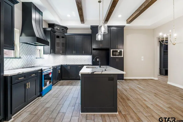 a kitchen with a sink stainless steel appliances a counter space and cabinets