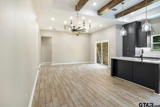 a view of an empty room and kitchen view