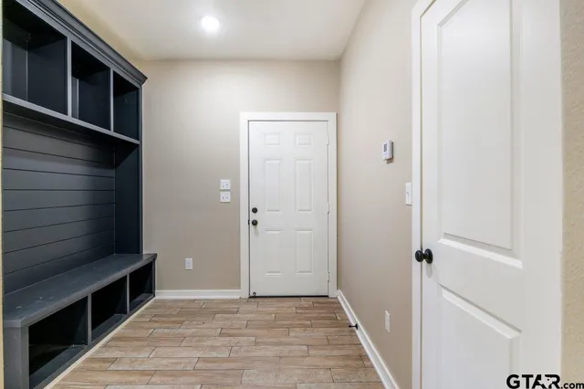 a view of a hallway with wooden floor and staircase