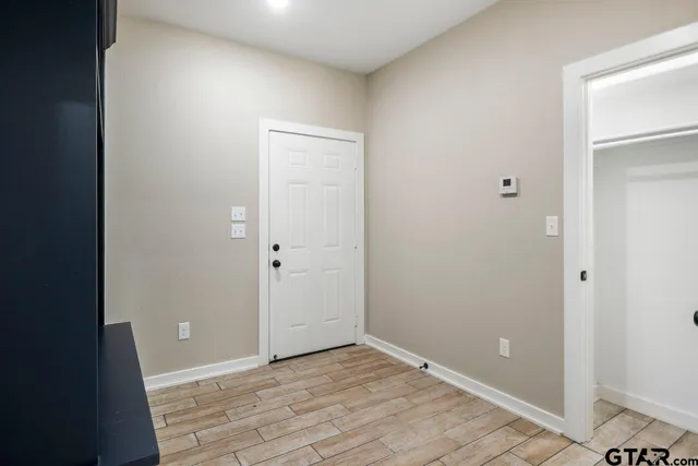 an empty room with wooden floor and entrance