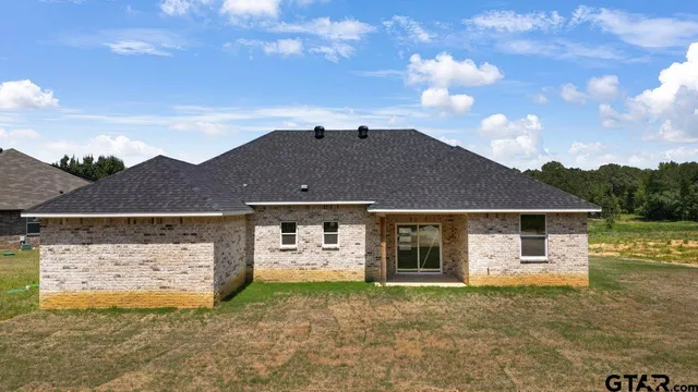 a front view of a house with a garden and yard