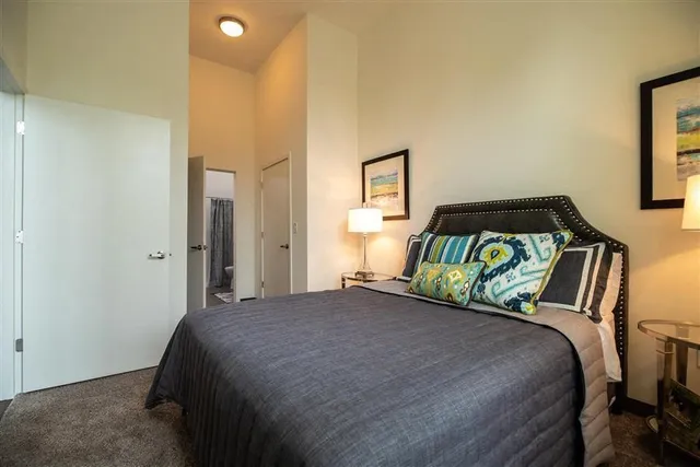 a bedroom with a bed and a painting on the wall