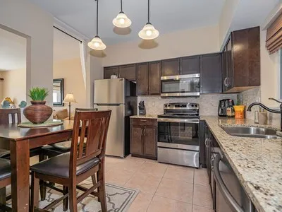 a kitchen with stainless steel appliances a dining table and chairs