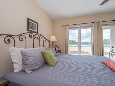 5075 Harmony Circle, Unit 302 Vero Beach, FL 32967 - Photo 16 of 32 a bedroom with a bed and a large window