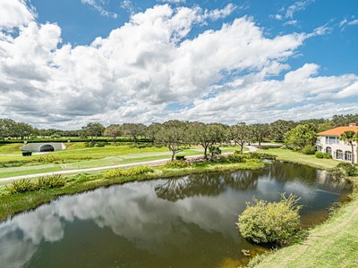 5075 Harmony Circle, Unit 302 Vero Beach, FL 32967 - Photo 30 of 32 a view of a lake with houses in the back