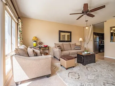 a living room with furniture a ceiling fan and a rug
