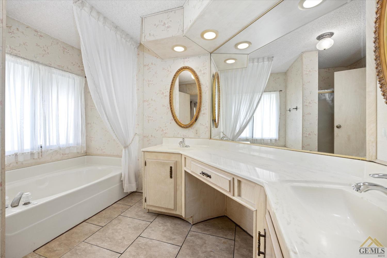 Undisclosed Address Bakersfield, CA 93306 - Photo 21 of 32 a bathroom with a granite countertop sink mirror and a bathtub