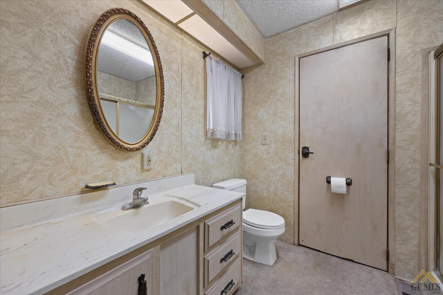 Undisclosed Address Bakersfield, CA 93306 - Photo 24 of 32 a bathroom with a toilet sink and mirror