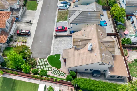 an aerial view of a house with a yard and potted plants