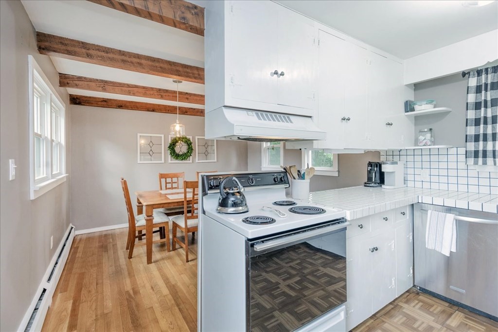14 Francis Wyman Road Burlington, MA 01803 - Photo 11 of 39 a white kitchen with a stove a table and chairs in it