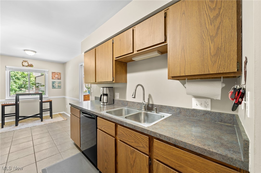 889 Hampton Ridge Drive Akron, OH 44313 - Photo 24 of 38 Kitchen featuring light tile patterned floors, sink, and stainless steel dishwasher