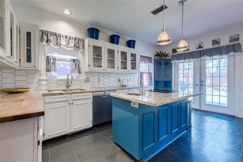 a kitchen with granite countertop cabinets a sink and stainless steel appliances