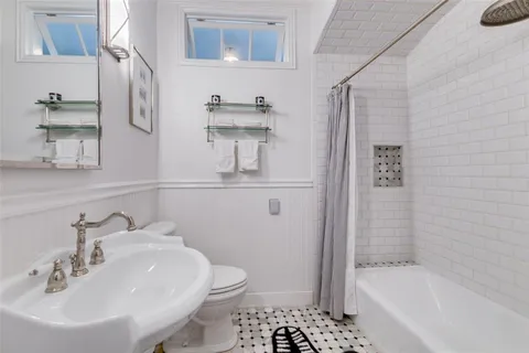 a bathroom with a sink a toilet and shower