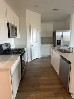 a kitchen with a sink stove top oven and refrigerator