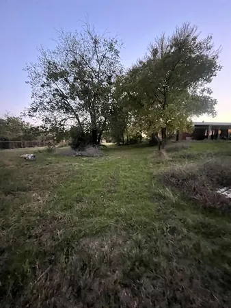 a view of a field with trees in the background