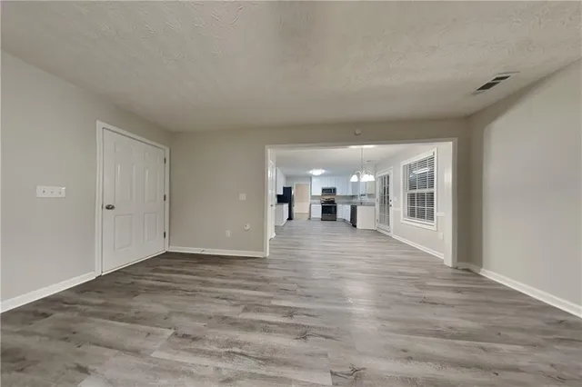a view of empty room with wooden floor