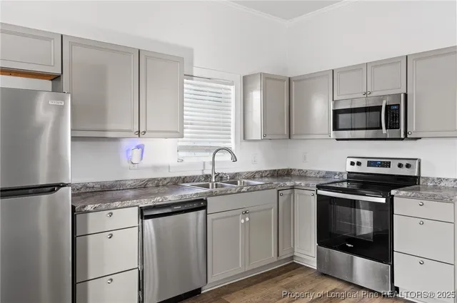 a kitchen with stainless steel appliances granite countertop a sink stove microwave and refrigerator