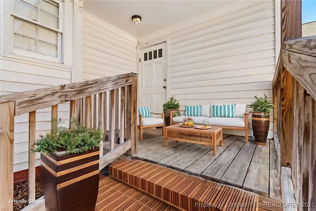 a view of a deck with couches table and chairs with wooden floor and potted plants