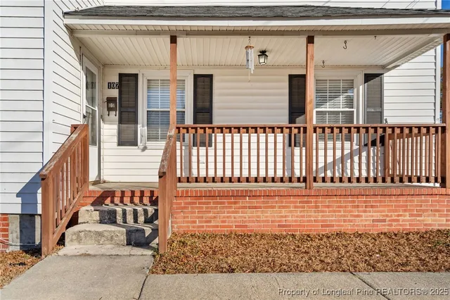 a view of a brick house with wooden floor and fence