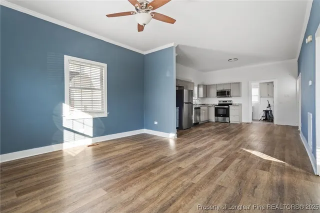 a view of empty room with wooden floor and window