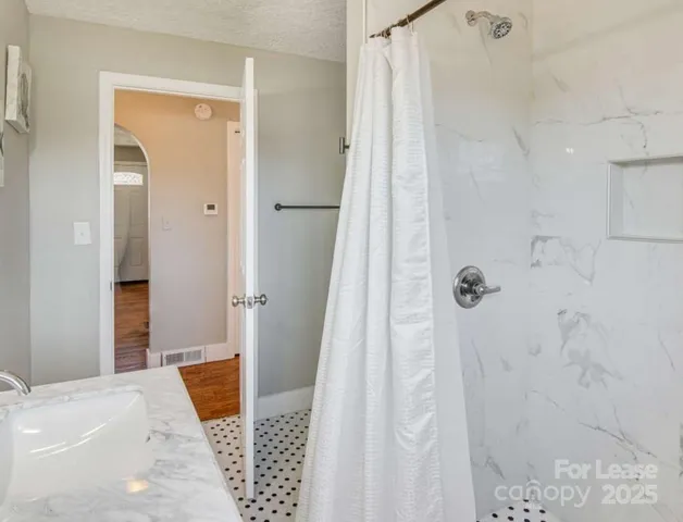 a bathroom with a shower and a sink