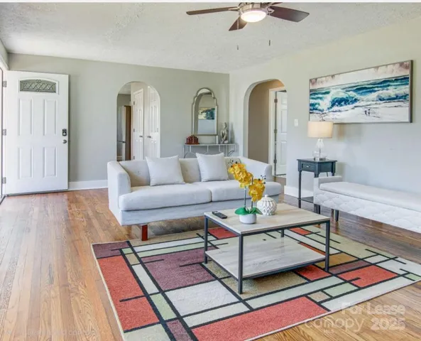 a living room with furniture and wooden floor