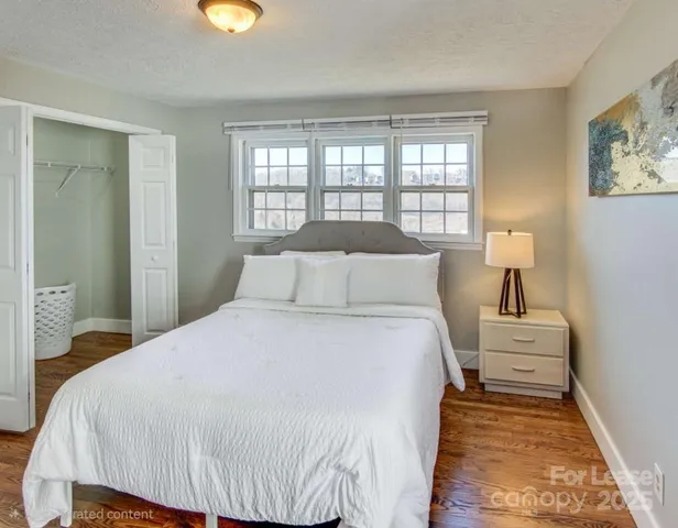 a bedroom with a bed and painting on the wall