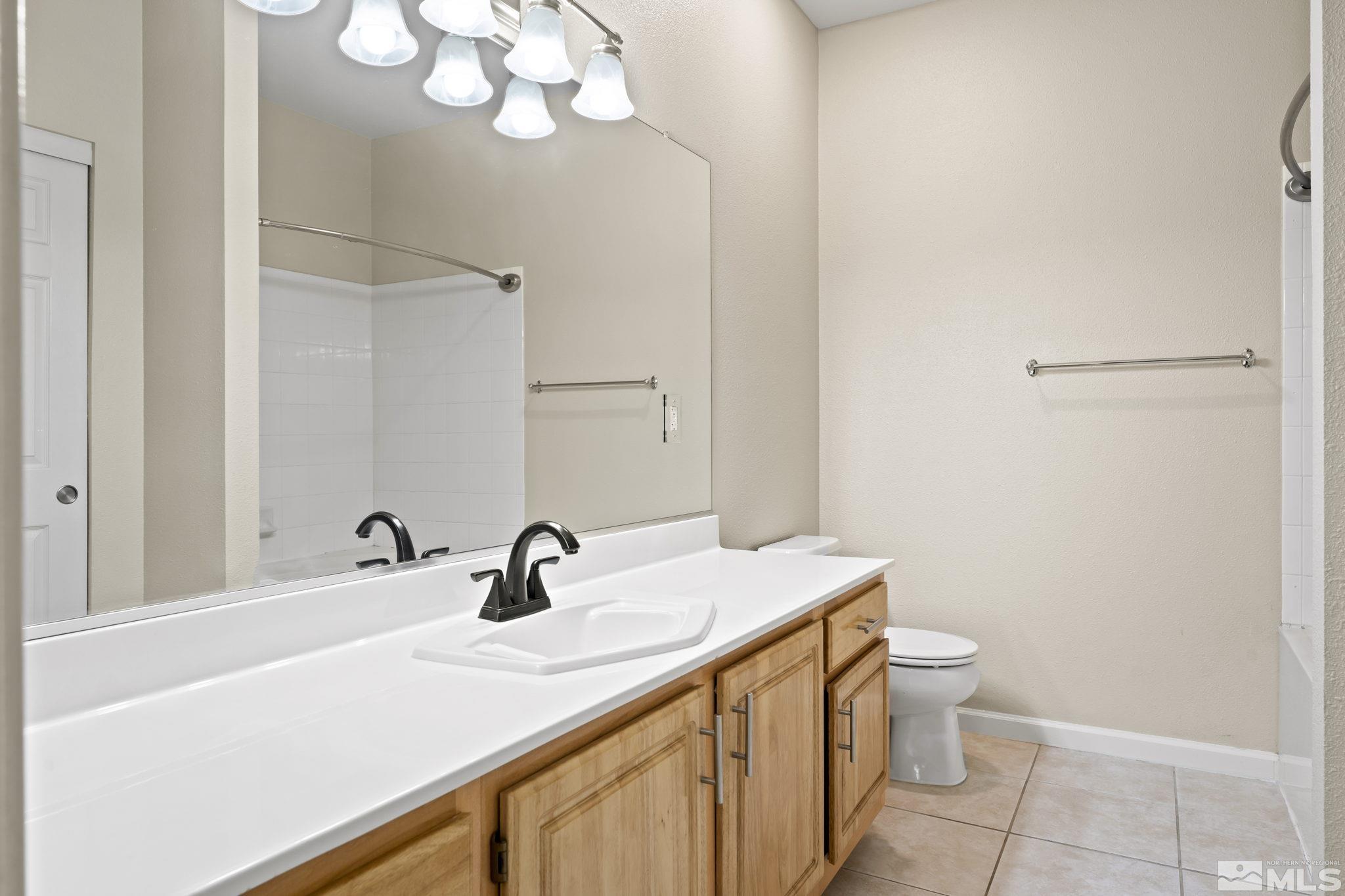900 South Meadows Parkway, Unit 321 Reno, NV 89521 - Photo 13 of 40 a bathroom with a sink a toilet and a mirror
