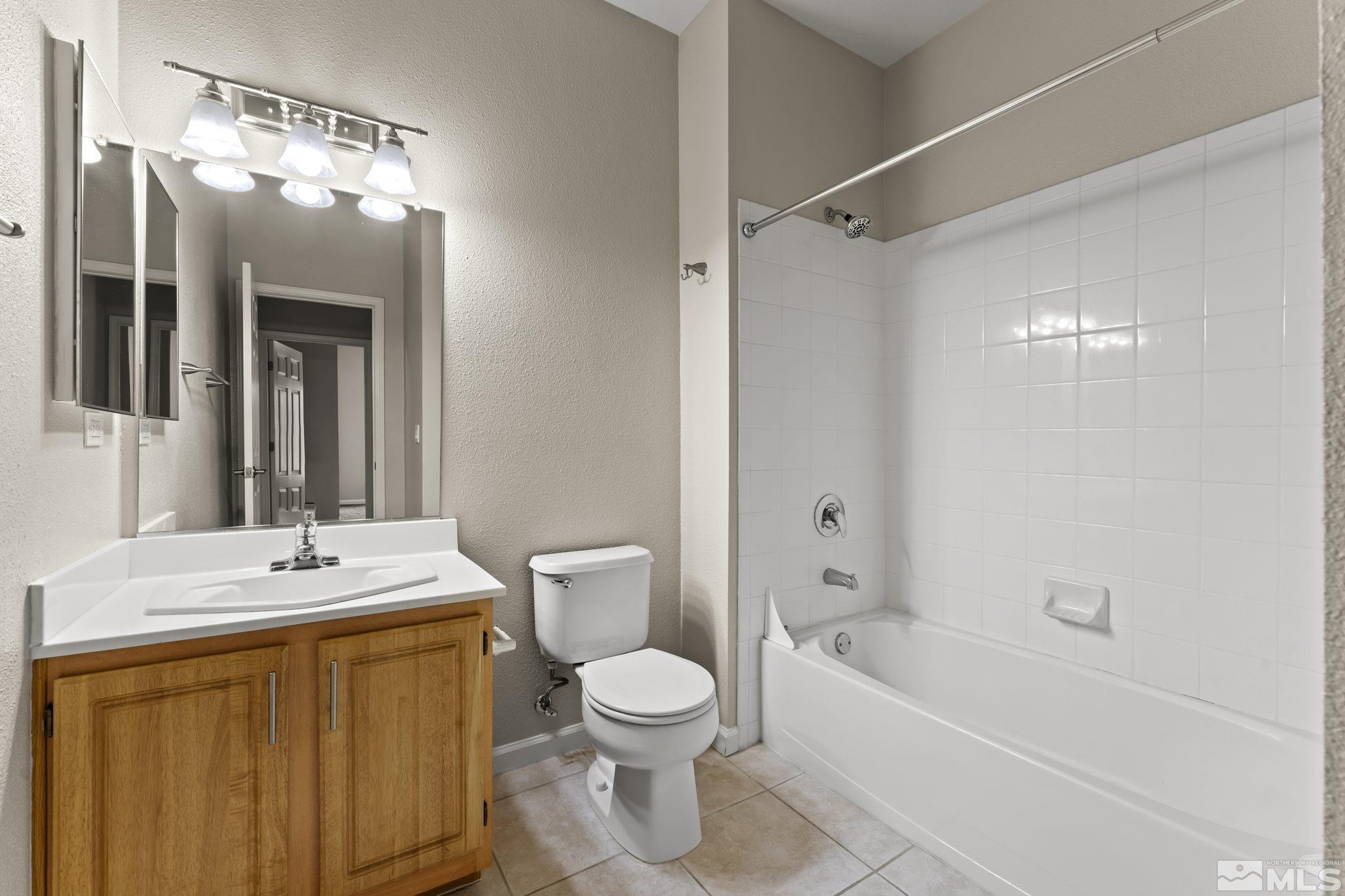900 South Meadows Parkway, Unit 321 Reno, NV 89521 - Photo 18 of 40 a bathroom with a toilet a sink and a bathtub