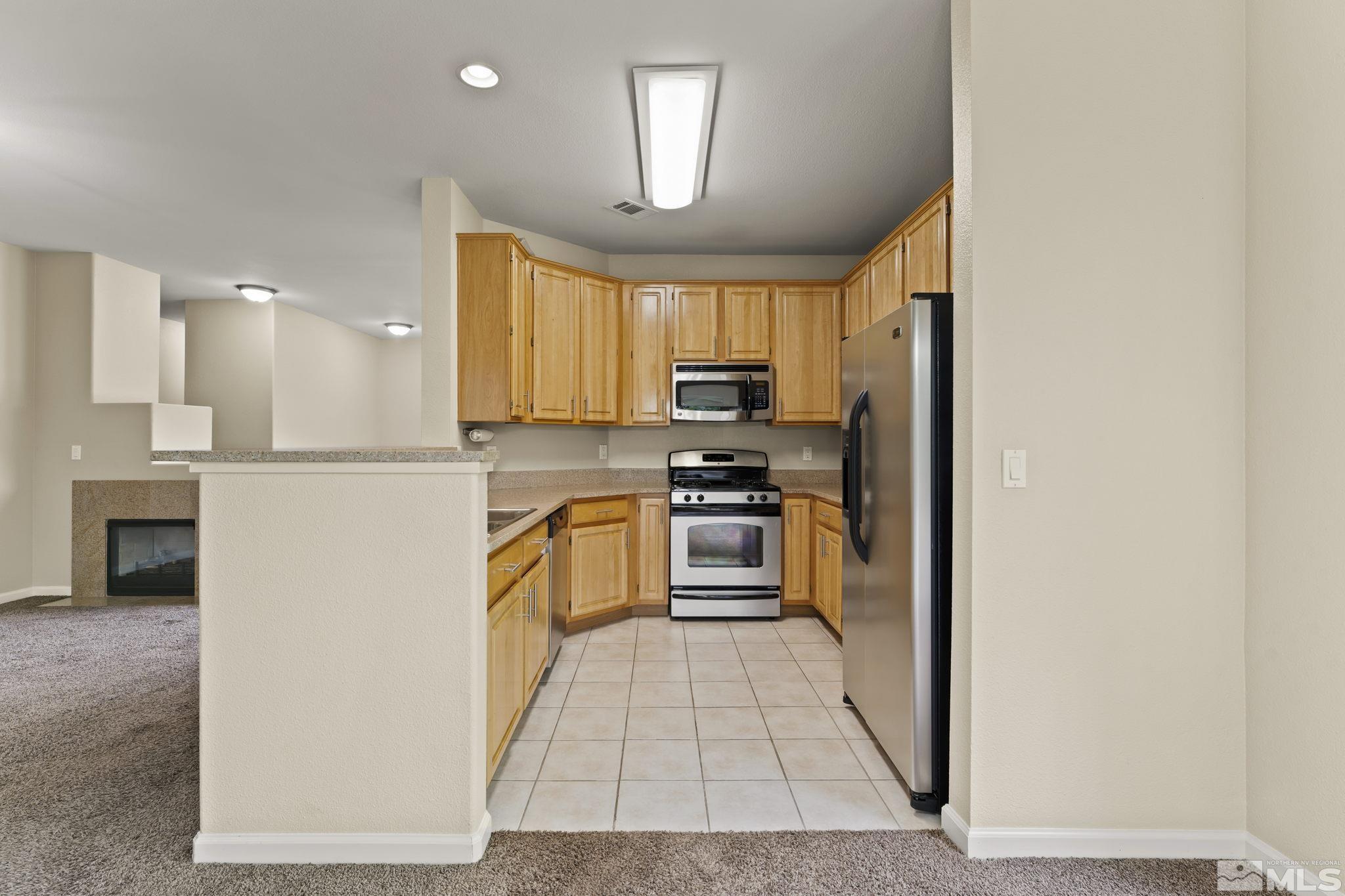 900 South Meadows Parkway, Unit 321 Reno, NV 89521 - Photo 20 of 40 a kitchen with a refrigerator a stove top oven a sink and dishwasher