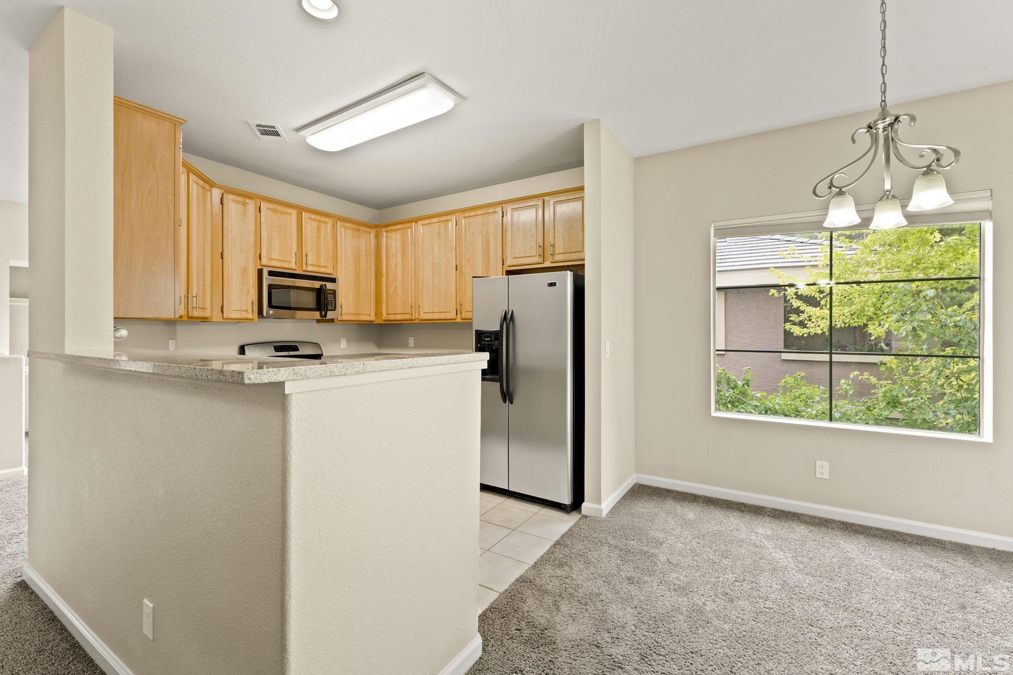 900 South Meadows Parkway, Unit 321 Reno, NV 89521 - Photo 21 of 40 a kitchen with stainless steel appliances a refrigerator sink and microwave