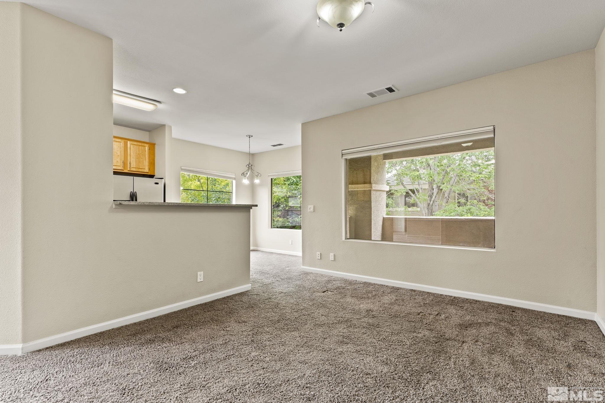 900 South Meadows Parkway, Unit 321 Reno, NV 89521 - Photo 23 of 40 an empty room with a window and a kitchen