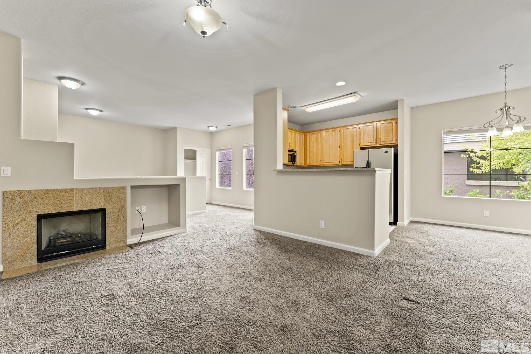 900 South Meadows Parkway, Unit 321 Reno, NV 89521 - Photo 4 of 40 an empty room with furniture and a fireplace