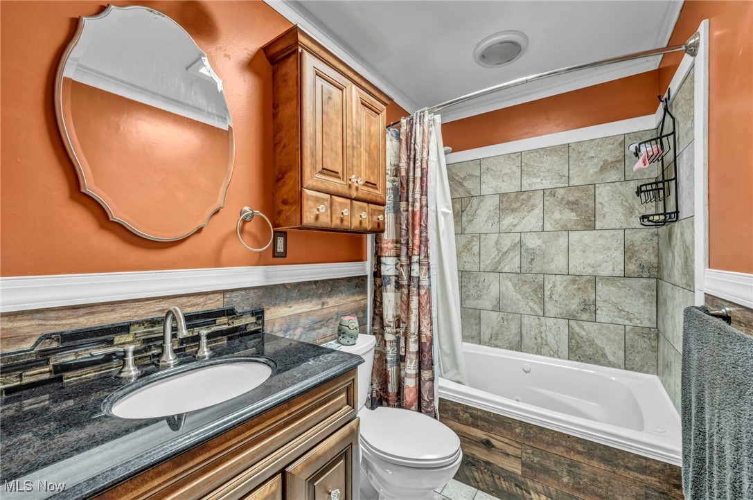 10982 Root Road Columbia Station, OH 44028 - Photo 17 of 49 Bathroom with tiled shower / bath combo, vanity, crown molding, and tile walls