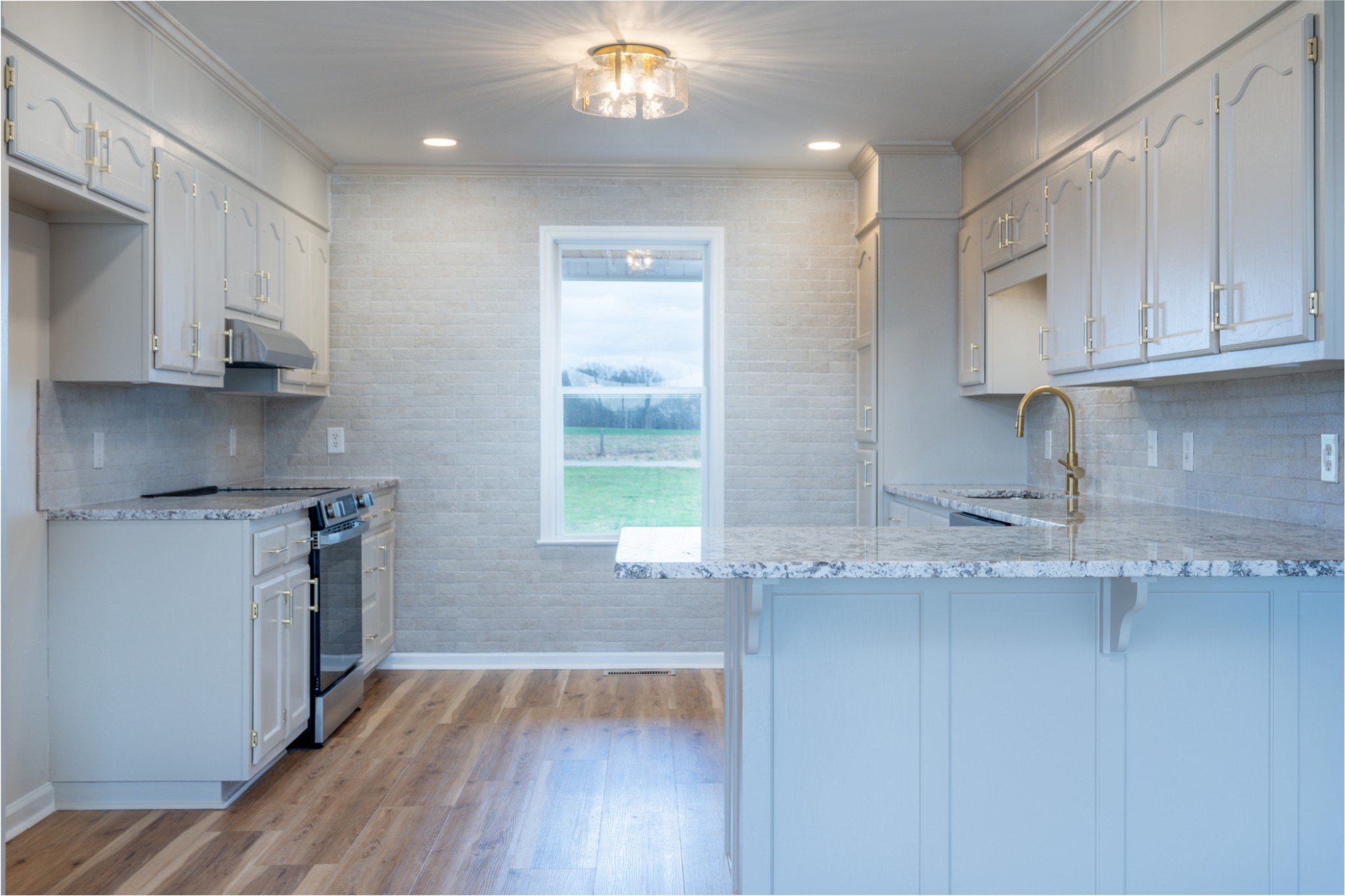 105 Peppertown Road Loretto, TN 38469 - Photo 12 of 37 a kitchen with granite countertop a sink cabinets and stainless steel appliances