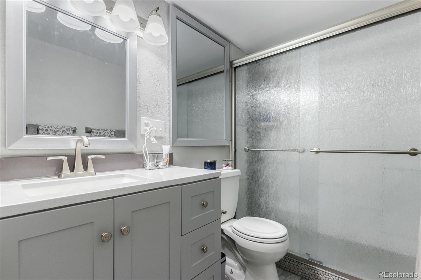 888 Logan Street, Unit 2F Denver, CO 80203 - Photo 14 of 16 a bathroom with a toilet sink and mirror