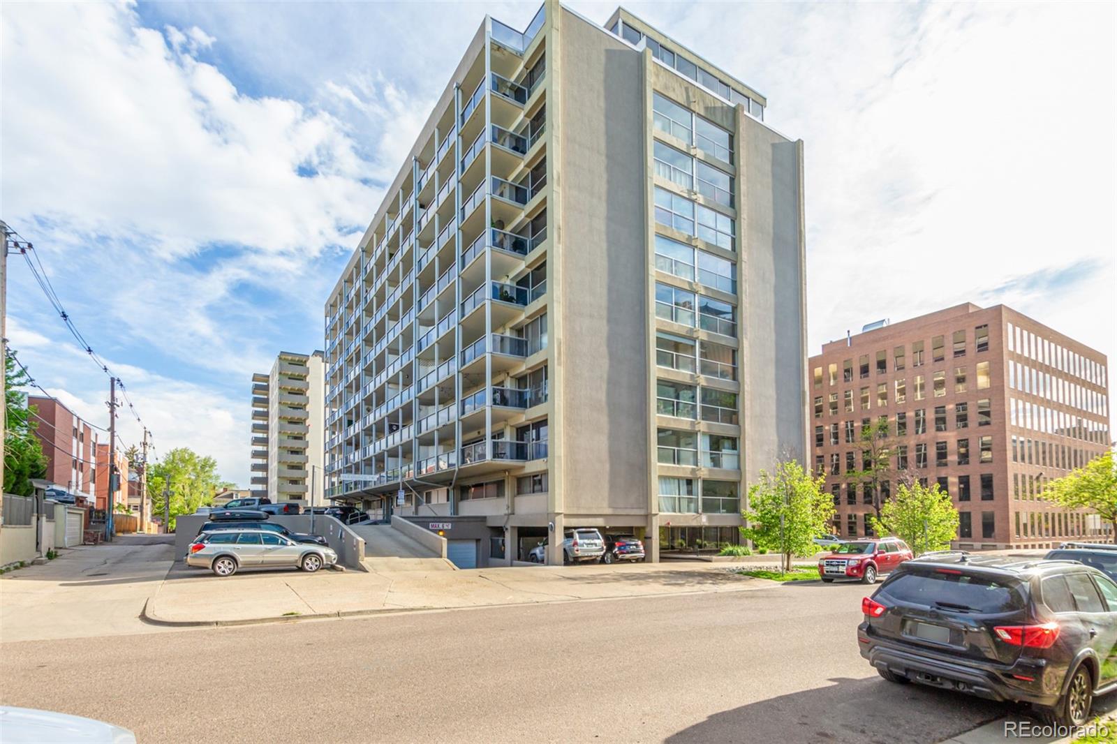 888 Logan Street, Unit 2F Denver, CO 80203 - Photo 5 of 16 a car parked in front of a tall building