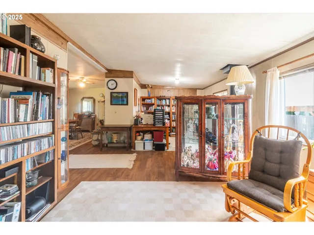 a living room with stainless steel appliances furniture a rug and a view of kitchen
