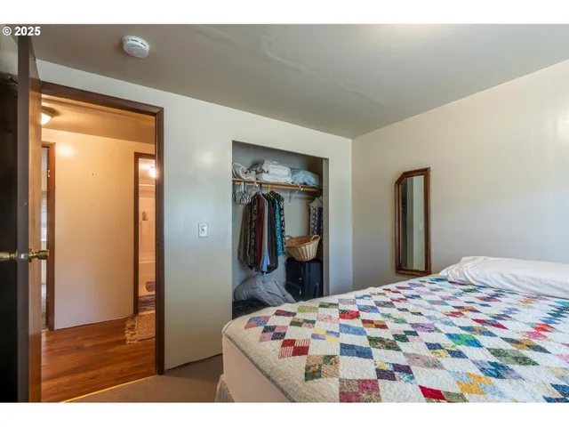 a bed sitting in a bedroom next to a window with bookshelf