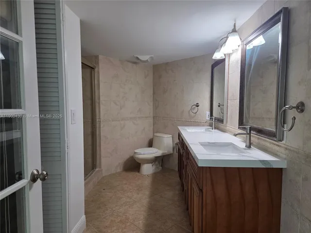 a white toilet sitting next to a bathroom sink