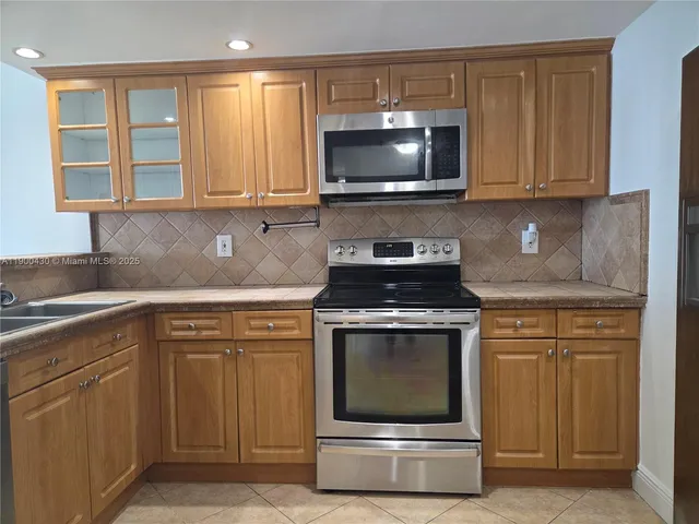 a kitchen with granite countertop a stove and a microwave