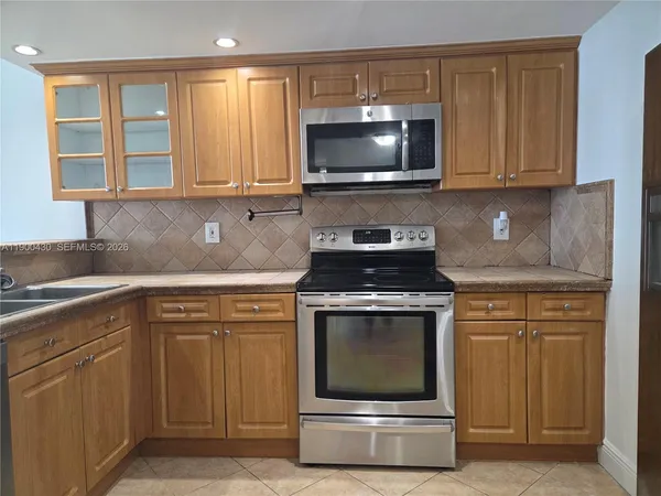 a kitchen with granite countertop a stove and a microwave