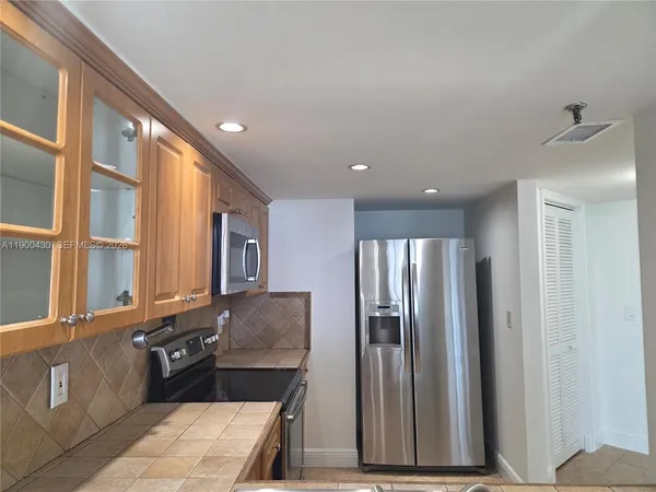 a kitchen with stainless steel appliances granite countertop a refrigerator and a stove