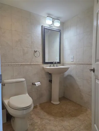 a bathroom with a sink a toilet and mirror