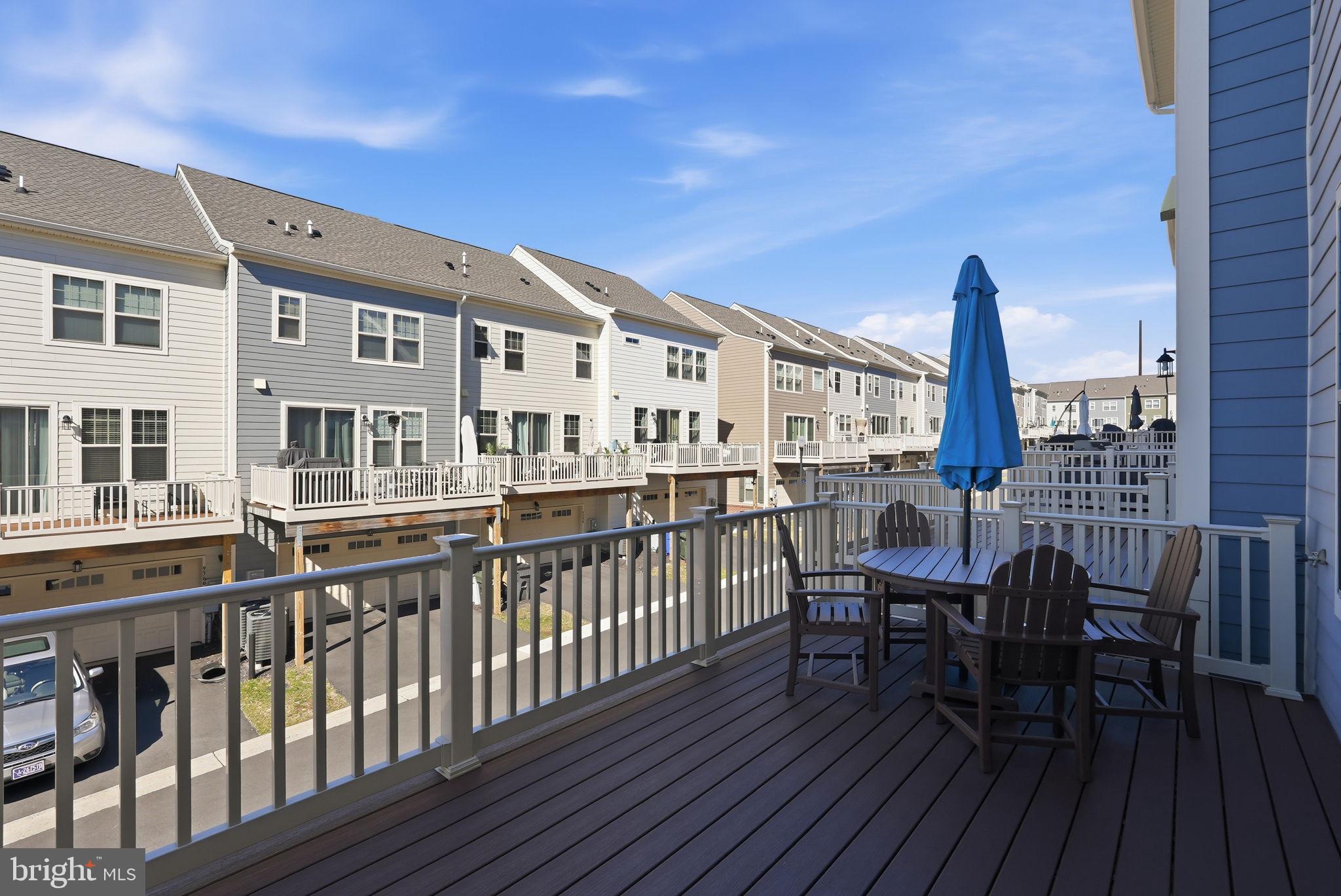 9365 Barnes Loop Manassas, VA 20110 - Photo 24 of 37 a view of a roof deck with table and chairs with wooden floor and fence
